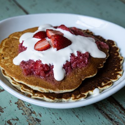 Berries and cream pancakes topped with strawberries.