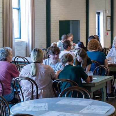 Busy cafe dining room with guests at tables.