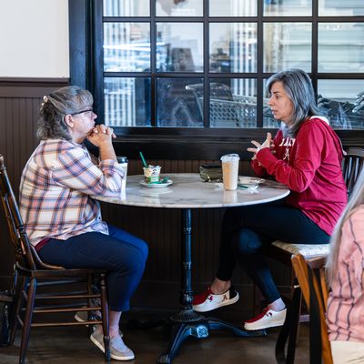 Coffee shop guests by the big windows.