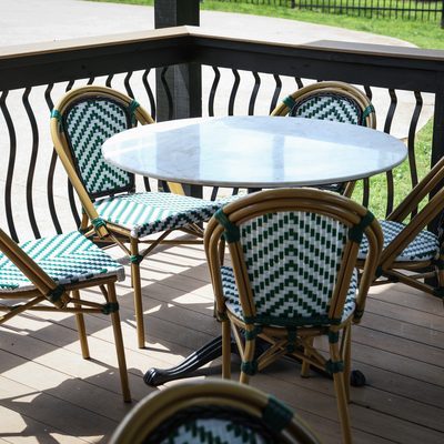 Patio bistro table with green and white chairs.